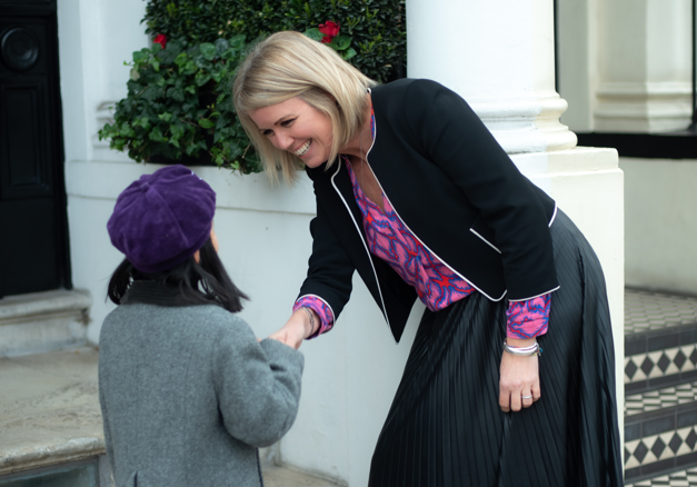 Nina Kingsmill Moore - Headteacher at Glendower Prep School - giving a girl a handshake 
